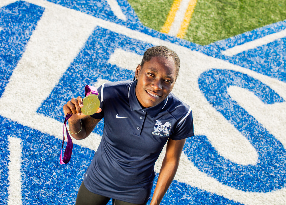 Brittney Reese holds 2012 Long Jump Gold Medal on field at San Diego Mesa College.