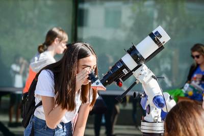 student looking into a telescope